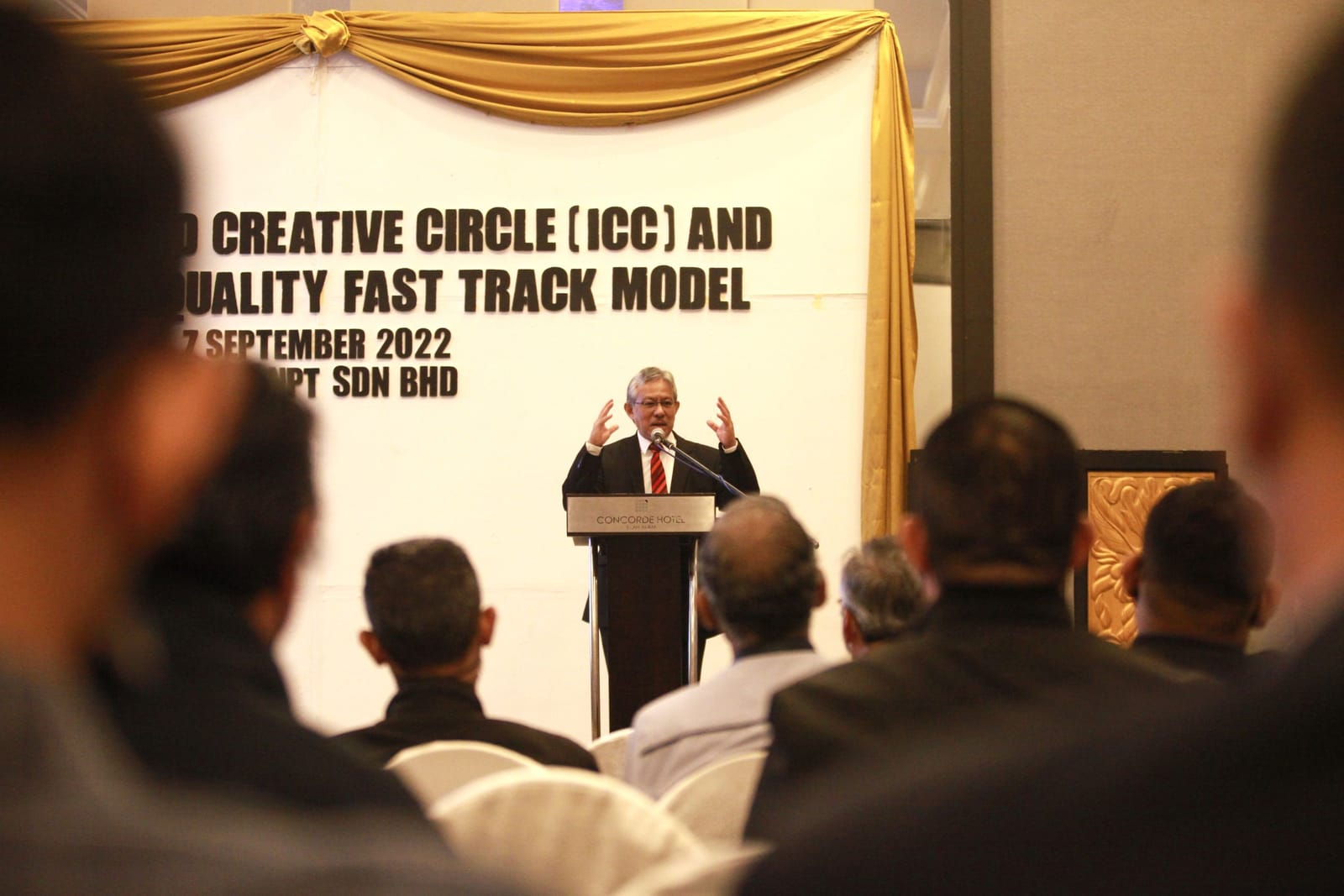 A speaker at the podium addressing participants at the ICC and SIRIM Total Quality Fast Track Model workshop