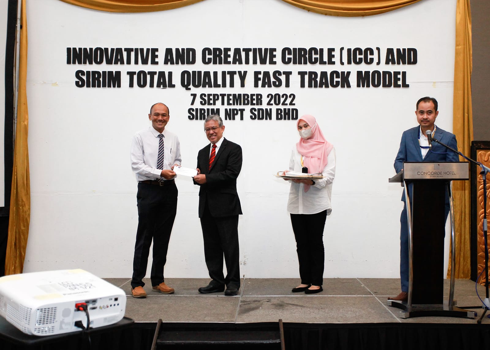 A token of appreciation presented on stage beneath the workshop banner