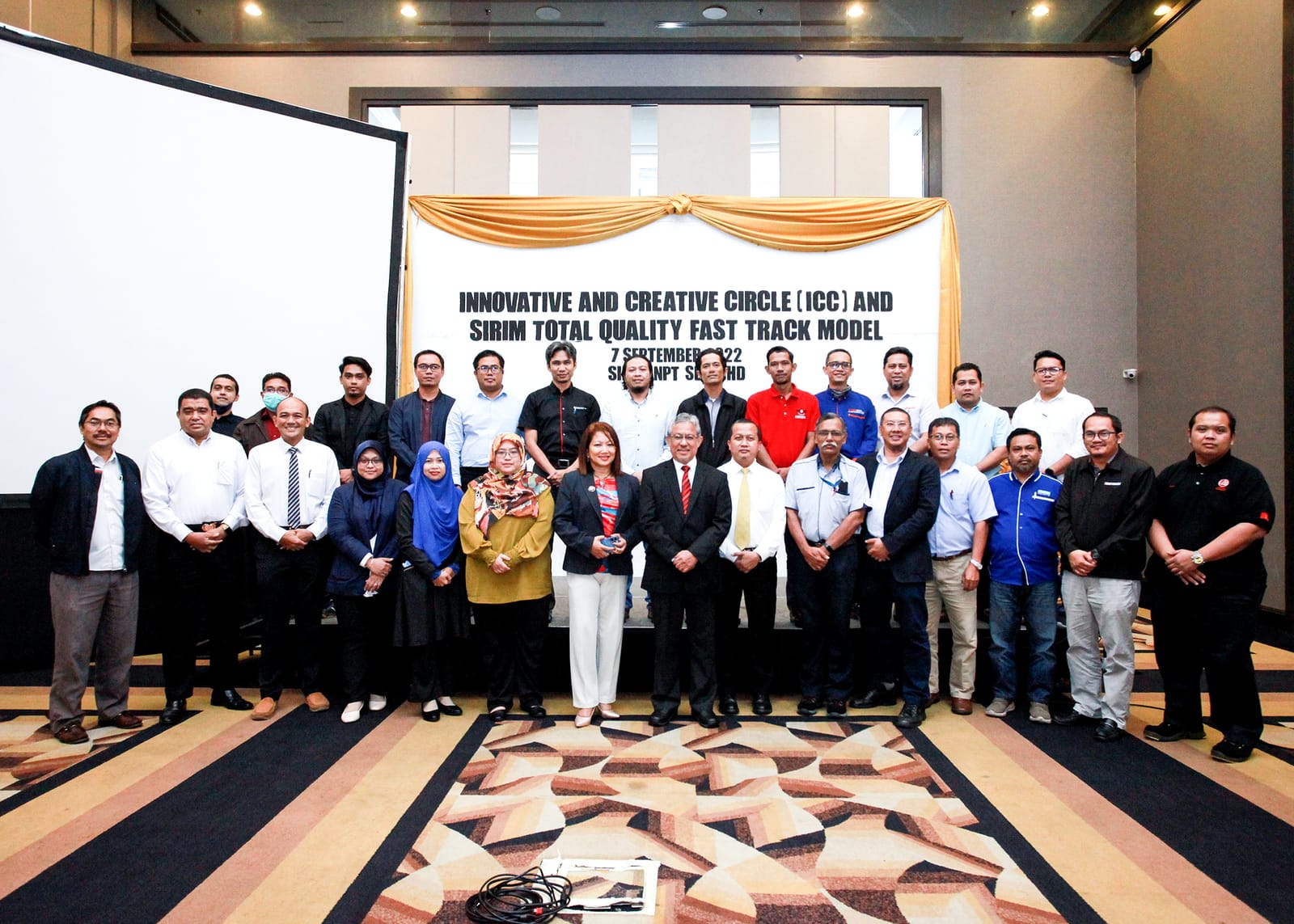 Group photograph of the workshop participants in front of the banner