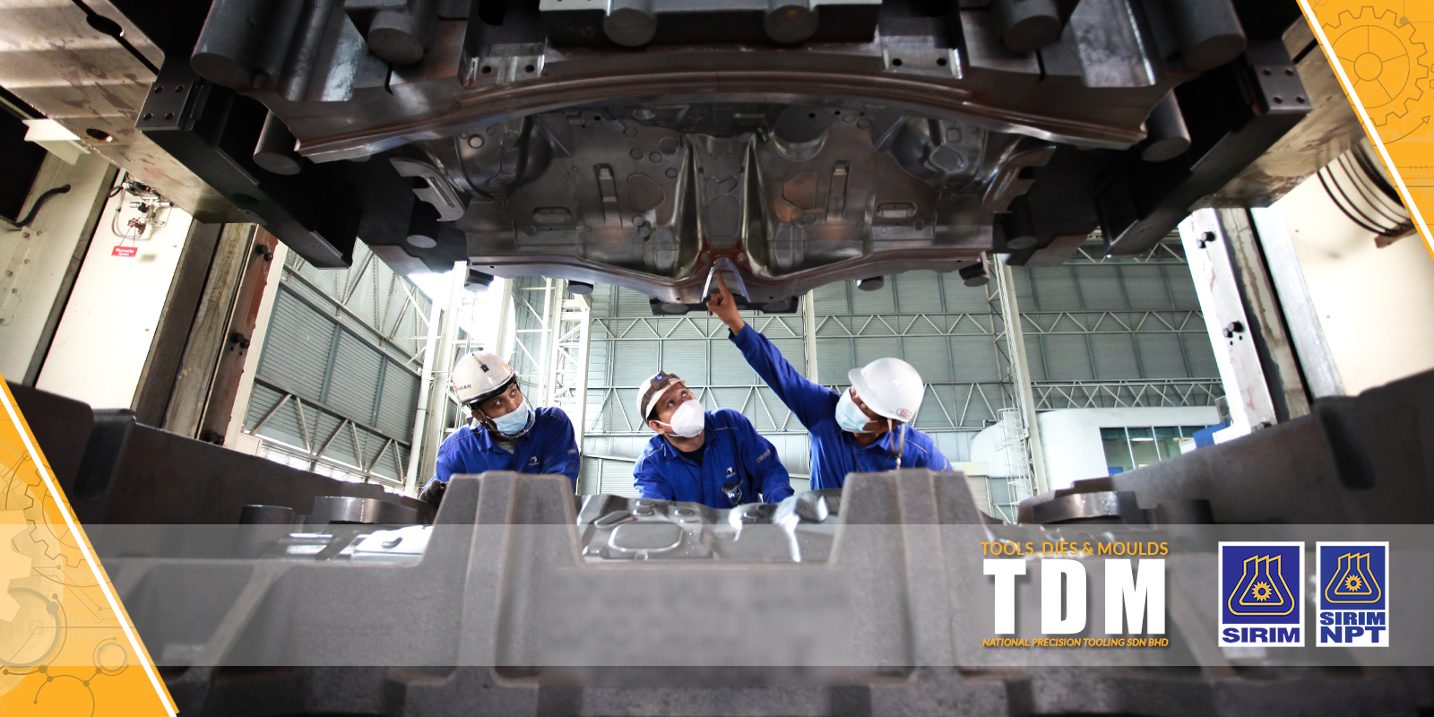 Three technicians in hard hats inspecting the underside of a car body on a hoist — TDM, Tools, Dies and Moulds, National Precision Tooling Sdn. Bhd.