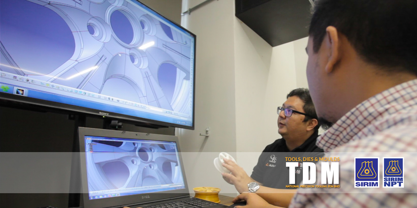 An engineer reviewing a 3D CAD model of a die on screen with a colleague — TDM, Tools, Dies and Moulds