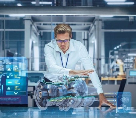 An engineer studying a holographic 3D model of an engine over a workbench