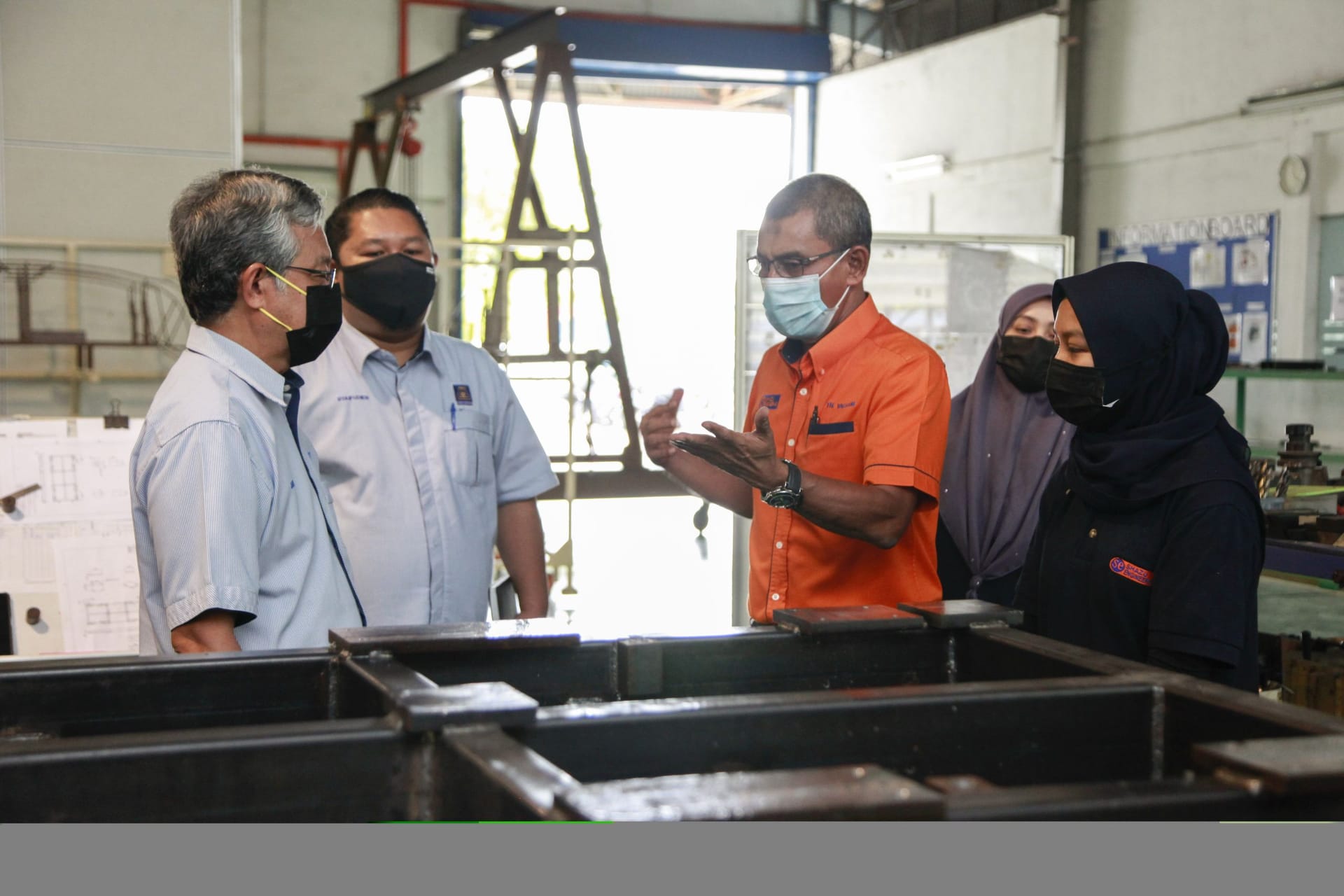 Engineers in discussion on a factory floor
