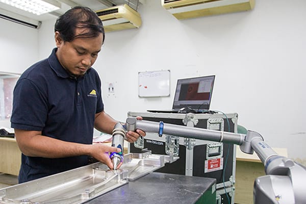 A technician setting up a measuring instrument on a machine